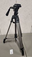 Full view of the Propod camera tripod showing three extendable metal legs, pan handle and mounting plate