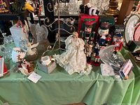 Photo of nutcrackers, ceramic pitcher, porcelain angel, and assorted Christmas decorations on a table with green tablecloth