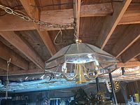 Hanging chandelier light fixture with brass frame and glass panels photographed from below