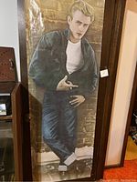 Life size James Dean poster showing him in a casual pose leaning against a brick wall.