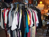 Full view of rack showing mixed T-shirts, tops, jackets and pants on hangers