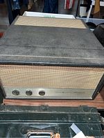 General Electric stereophonic receiver unit showing speaker grille, control knobs, and textured black casing.