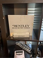 Bentley Deluxe Battery Charger box and Bentley DC Auto Adapter box placed on shelf