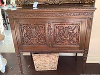 Front view showing carved double-door panels and central finial detail
