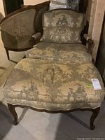 Armchair and ottoman set front view showing upholstery pattern and carved wood frame