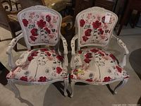 Front view of pair of chairs showing upholstery pattern and carved wood frame
