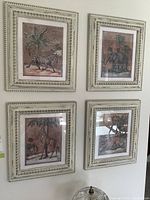 Four framed animal prints on wall including zebra, elephant, giraffe, and deer.