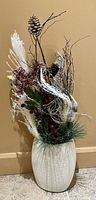 Front view of birch Christmas arrangement showing pine cones, birch wood pieces, berries, and feathery white accents in white vase