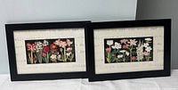 Two framed floral prints side by side showing colorful flower arrangements titled 'Blooming Reds' and 'Blooming Whites'
