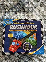 Front of new unopened Rush Hour Deluxe Edition game box with colorful car graphics