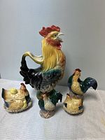 Ceramic rooster pitcher, salt & pepper shakers, ceramic chicken jar with chick on back and lid, and creamer arranged on table