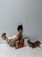 Set of three rooster figurines displayed together including ceramic and copper pieces