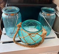 Front view of all three turquoise glass decor items showing textures and handles.