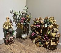 Three-piece set of locally crafted Christmas decor items shown together on wooden floor against wall corner.