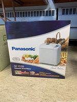 Box showing Panasonic branding, model SD-YD250, automatic bread maker with image of bread and ingredients
