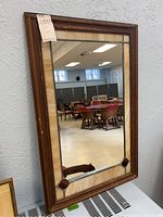 Front view of rectangular wood framed stained glass mirror with cream and red glass accents.