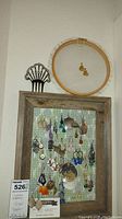 Wide shot of the barnwood frame earring holder with an embroidery hoop earring holder above it, showing many pairs of hanging costume earrings.
