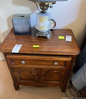 Photo showing one Drexel wooden nightstand with drawer and two-door cabinet, some items placed on top (not included)