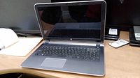 Open HP laptop showing screen, keyboard, and touchpad