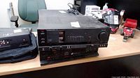Amplifier and cassette deck stacked on table