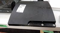 Front and top view of black Sony PlayStation 3 console showing overall shape and condition