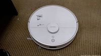 Top view of white 360 robot vacuum cleaner showing brand and buttons.