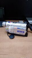 Side view of JVC Super VHS camcorder showing lens, zoom labeling and Super VHS branding.