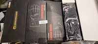 Four boxed pairs of black Trittons battery powered rechargeable heated gloves with accessories in a plastic bag.