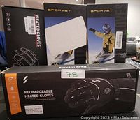 Four boxes of Sporvet rechargeable heated gloves with battery power, labeled 7B, showing gloves image on front and person wearing winter gear on side boxes.