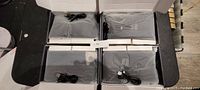 Four boxed pairs of black heated socks, each with a USB charging cable, packaged inside individual plastic wraps.