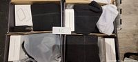 Four pairs of black heated socks neatly folded in original packaging along with battery packs and chargers, all photographed from above.