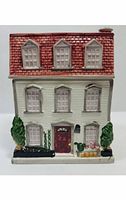Front view of the ceramic Victorian house cookie jar showing detailed windows, front door, and greenery decorations.