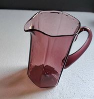 Front and side view of the small purple glass pitcher showing hexagonal base and curved handle.