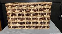 Side view showing the woven wicker pattern in natural beige and dark brown, rectangle shape.
