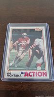 Front side of 1982 Topps Joe Montana football card showing player in red uniform in action, with 'IN ACTION' text.