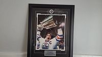 Framed photo of Wayne Gretzky holding the Stanley Cup, showing the upper portion with the image and plaque below.