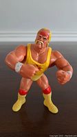Front view of WWF Hasbro Hulk Hogan action figure in yellow and red wrestling outfit showing muscular build and facial details