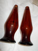 Two brown glass beer bottles, non-refillable and non-refundable, standing upright on white paper towel, showing their tapered shape and brown color.