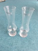 Two Tarnow shooter glasses made of clear glass with base and slightly curved shape. Marked with Tarnow logo.