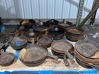 Front view of multiple stacks of Lodge cast iron skillets on pallet