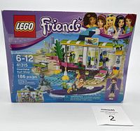 Front box image of LEGO Friends Heartlake Surf Shop set showing the main assembled building, figurine, and kayak with 186 pieces indicated.