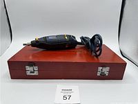 Rotary tool on top of closed wooden case stored on white background