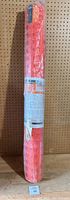 Full view of the orange plastic snow fence roll standing upright showing the packaging and label.