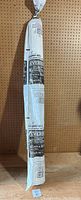 Full view of the rolled vapor barrier with packaging showing hanging against pegboard background.