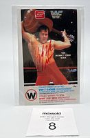 Front of the collectible card showing The Honky Tonk Man in red wrestling gear posing with a guitar, autographed in red ink.