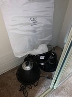 Three pieces of photographic lighting equipment including Alzo Digital branded softbox and two lighting units on carpeted floor