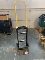 Front view of the hand cart with adjustable yellow handle and base plate with American flag sticker.