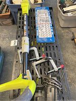 Overview image showing Ryobi blower, socket set, clamps, and shelving on the floor.