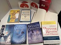 Photo showing all books and 6-CD set spread out on table including three Wendy Darling books, 99 Percent Mine, The Last Juror, The Last Person You Meet In Heaven, and Prevent and Reverse Heart Disease Tools CDs.