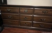 Full front view of 9 drawer wooden dresser showing drawer condition and hardware.